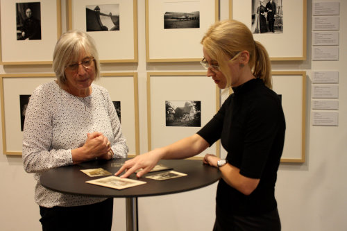 Ausstellungsbesucherin Luzie Kunde (l). hat alte Fotos aus ihrer privaten Sammlung mitgebracht und liefert Denise Trump (r.), Museum und Forum Schloss Homburg, wichtige Erkenntnisse zu den ausgestellten Bildern. (Foto: OBK)