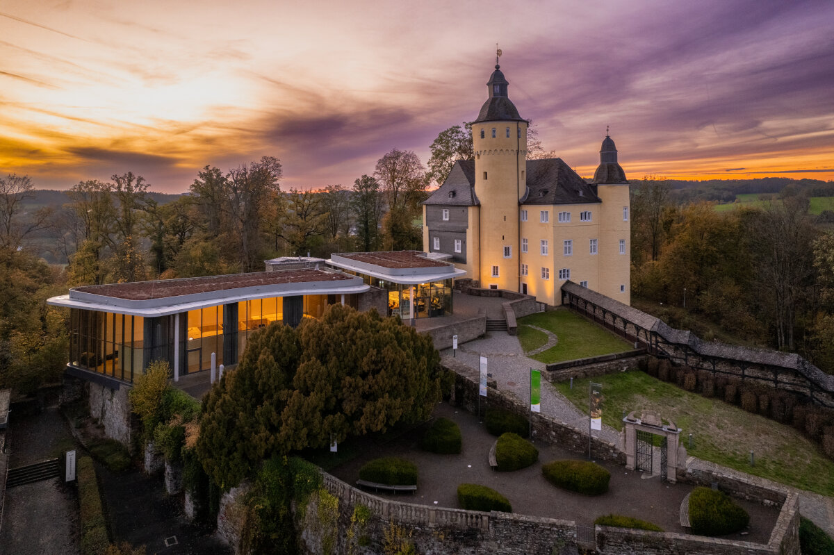 Ein Schloss auf einem Berg bei Sonnenuntergang
